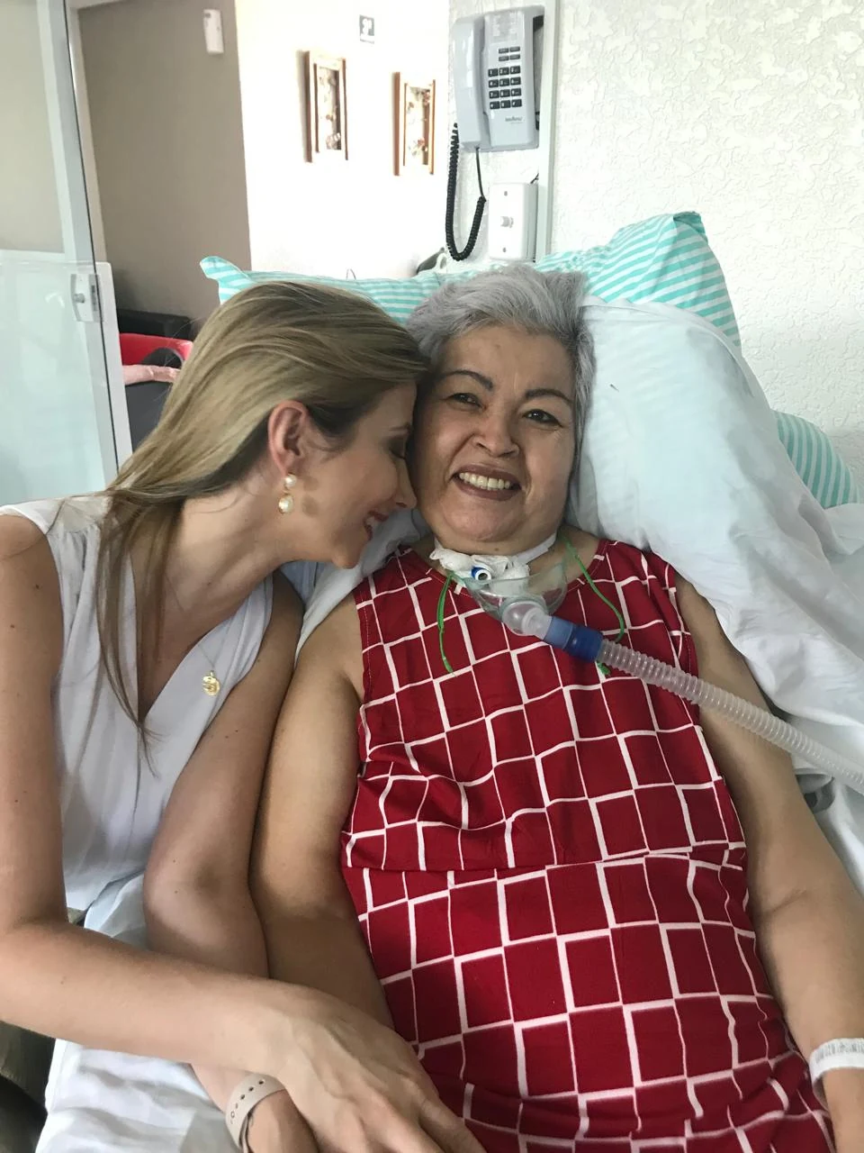 Dra. Juliana Venites ao lado de uma paciente durante atendimento hospitalar